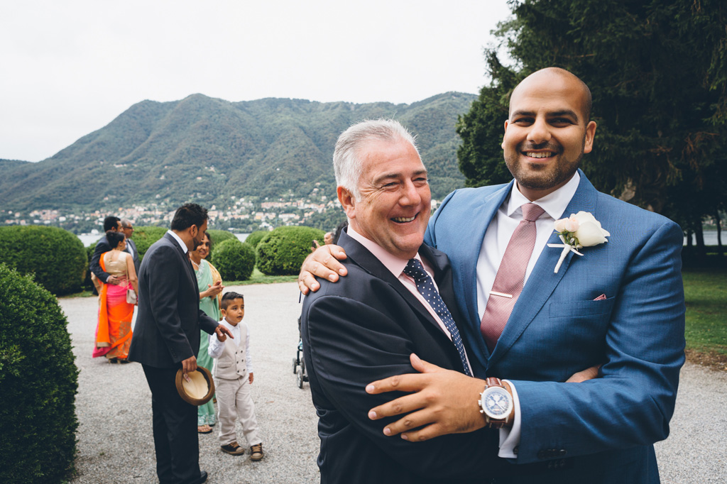 Fotografo Matrimonio Villa Erba Jaspal abbraccia amici e parenti prima della cerimonia di matrimonio