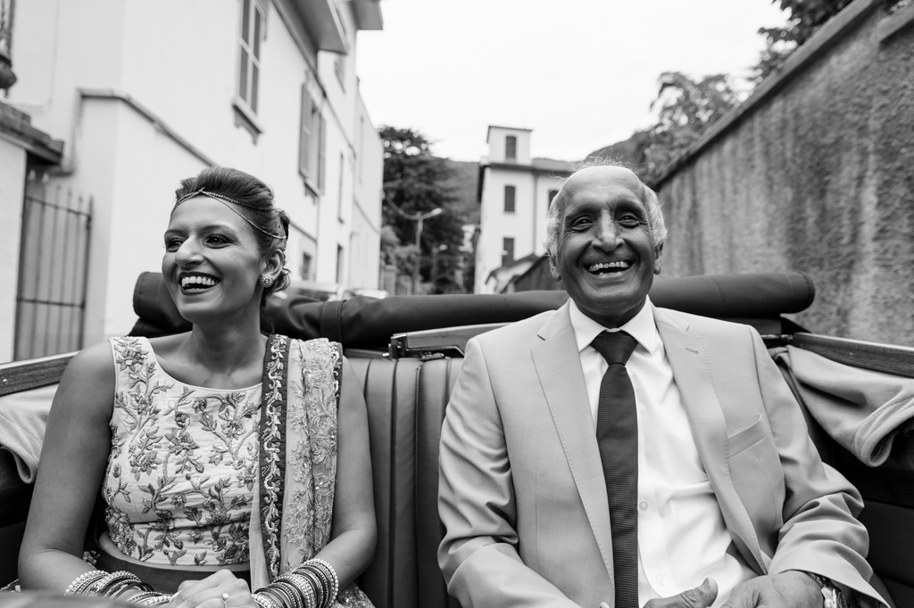 Fotografo Matrimonio Villa Erba Renaa ride allegramente in compagnia del padre durante il viaggio per il ricevimento