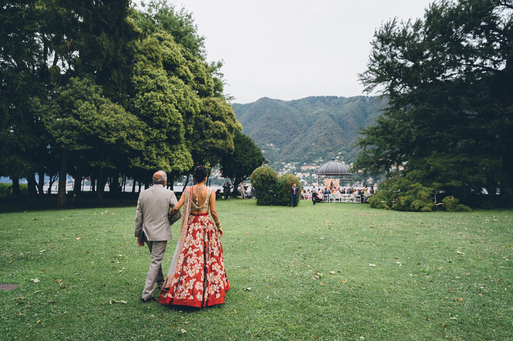 Fotografo Matrimonio Villa Erba Il padre cammina a braccetto con la sposa in direzione del luogo della cerimonia