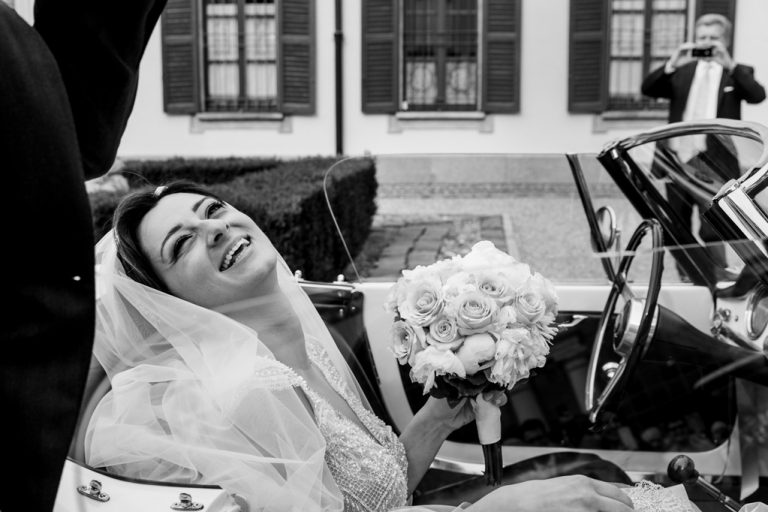 La sposa sorride raggiante in macchina