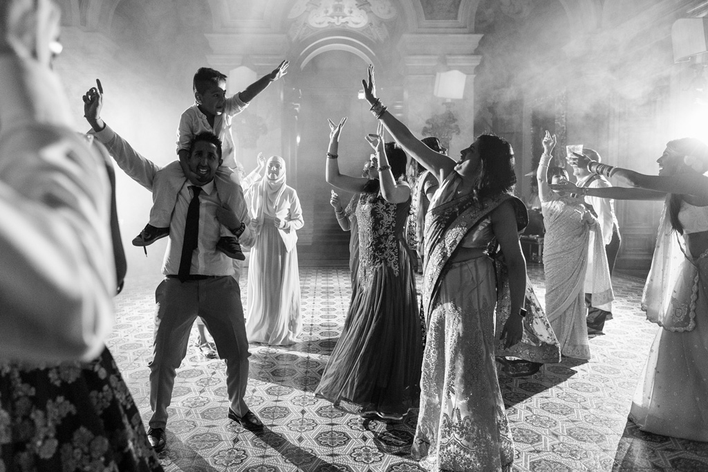 Fotografo Matrimonio Villa Erba Un invitato danza con un bambino sulle spalle