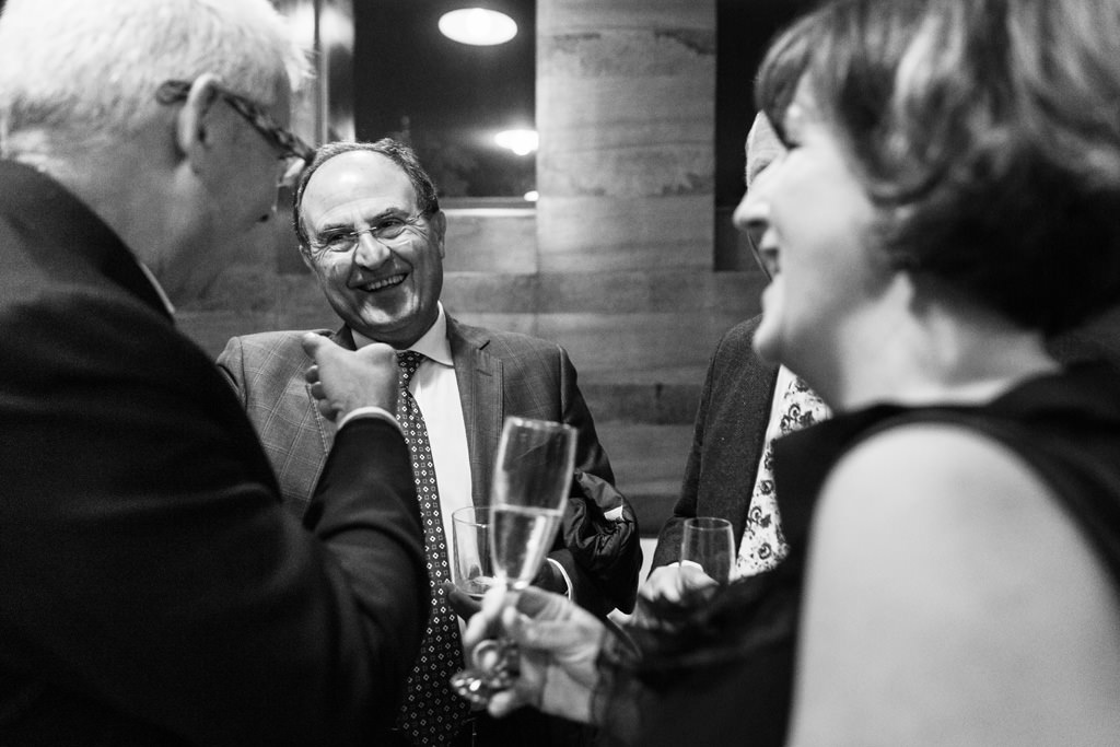 Fotografo Cena Aziendale Milano EUGA Villa Necchi Campiglio Alcuni partecipanti della cena scherzano con un aperitivo in mano